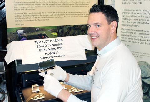 Councillor John Campion inspects the hoard of coins that was discovered on Bredon Hill.